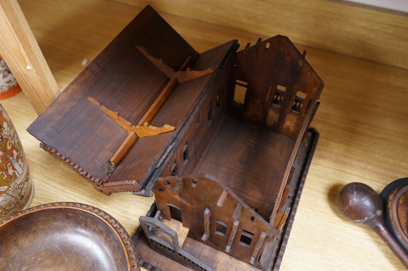 An early 20th century Black Forest carved walnut musical footed dish together with a model of a house (2)
